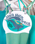 Swim cap design with woman diving above a whale and turtle, & JAYD Swimwear text above wave.
