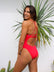 Side view of model wearing Airlie full-coverage athletic one piece swimsuit in Ruby Red by JAYD Swimwear.