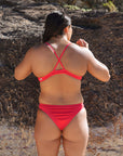 JAYD Swimwear's athletic bikini bottoms in the colour Ruby. Athlete Sara wears the Minnie bottom which offers a cheekiest coverage.