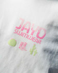 Fabric close-up of JAYD Swimwear's white oversized tee, printed with a pink JAYD Swimwear word mark and a western-inspired cactus and boots motif.