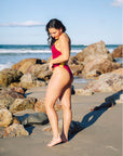 Side profile of a Tart pink Lennox one piece featuring contrasting daffodil contrasting straps and hip cut outs. Lennox is a mid coverage one piece.