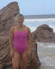 JAYD Swimwear design a fixed back athletic one piece called Lennox. It is seen on Athlete Taylor in the colour Orchid with contrasting sunshine straps.