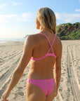 Back view of athletic cross-back JAYD Swimwear Kiama bikini top in Fairy Floss pink.