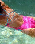 Underwater view of Zambia One Piece Athletic Swimsuit in Pink Sorbet with Mykonos contrast cutouts, by JAYD Swimwear.