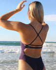 Close back strap view of model wearing JAYD Swimwear athletic Airlie one piece in Acai.