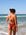 Back view of model walking on a beach wearing JAYD Swimwear athletic one piece Isla in Cinnamon.