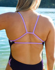 Close back strap view of model on beach wearing JAYD Swimwear athletic one piece swimsuit Zambia in Acai.