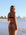 Back view of model on beach wearing JAYD Swimwear cheeky bikini bottom Demi in Ruby Red.