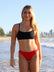 Front view of model on a beach wearing JAYD Swimwear athletic bikini top Torquay in Black.