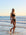 Front view of model on a rock wearing JAYD Swimwear mid-coverage bikini bottoms Tahiti in Black.