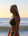 Side view of model wearing JAYD Swimwear athletic bikini top Nalu in Black.