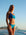Front view of model on  beach wearing JAYD Swimwear mid-coverage bikini bottoms Tahiti in Cancun Blue.
