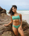Front view of model wearing JAYD Swimwear athletic Torquay training bikini top in Matcha green.