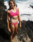 Olivia Corrin in the Pink Sorbet ZALI bikini bottom by JAYD Swimwear, designed with shape retention and chlorine-resistant fabric for active women of the water.