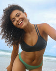 Front close view of model wearing JAYD Swimwear athletic Tazzie training bikini top in Carbon.