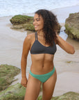 Front strap view of model wearing JAYD Swimwear athletic Tazzie training bikini top in Carbon.