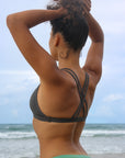 Back strap view of model wearing JAYD Swimwear athletic Tazzie training bikini top in Carbon.