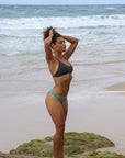 Side view of model wearing JAYD Swimwear athletic Tazzie training bikini top in Carbon.