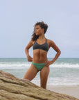 Front view of model wearing JAYD Swimwear athletic Tazzie training bikini top in Carbon.