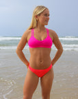 Front view of model wearing JAYD Swimwear athletic Tazzie training bikini top in Pink Sorbet.