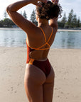 JAYD Swimwear open water swimmer Madi wears the fixed back Lennox one piece in the colour Cinnamon with contrasting sunshine straps and hip cut-outs. This piece offers mid coverage and is comfortable and durable for long training sessions