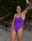 JAYD Swimwear surf ironwoman and kayaker Jasmine wears the fixed back Lennox one piece by JAYD Swimwear in the colour Murasaki with contrasting Cove straps and hip detailing. This piece offers mid coverage and is built for performance.