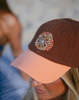 JAYD model wearing the brown and apricot baseball cap with 'Salty Summer' embroidery design.