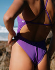 Person wearing a Murasaki purple Albi one piece by JAYD on a beach