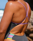 Close up of the Lennox one piece Carbon x Lilac Haze fixed back strap and contrasting multi-coloured hip cut-outs.