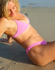 Side view of seamless, athletic, cheeky coverage JAYD Swimwear Minnie bikini bottoms in Fairy Floss pink.