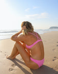 Back view of athletic cross-back JAYD Swimwear Kiama bikini top in Fairy Floss pink.