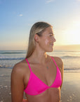 Close view of cross-back, athletic JAYD Swimwear Kiama bikini top in Pink Sorbet.