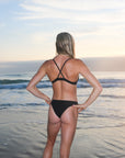 Back view of seamless, athletic, cheeky coverage JAYD Swimwear Minnie bikini bottoms in Black.