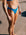 Brodee wears the Cali mid-coverage bottom in Cancun blue on a sandy beach