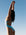 Madi wearing the Tallow One Piece swimsuit in MYKONOS blue against a clear blue sky.