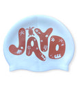White JAYD Swimwear swim cap in brown bubble letters with tropical island palm trees, turtle and shell icons.