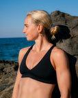 JAYD athlete Dom Stitt looking out towards the ocean wearing the supportive, fixed-back thick strap Vienna Bikini Top.