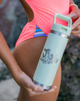 JAYD model holding the mint green water bottle with JAYD Swimwear logo in bubble font.