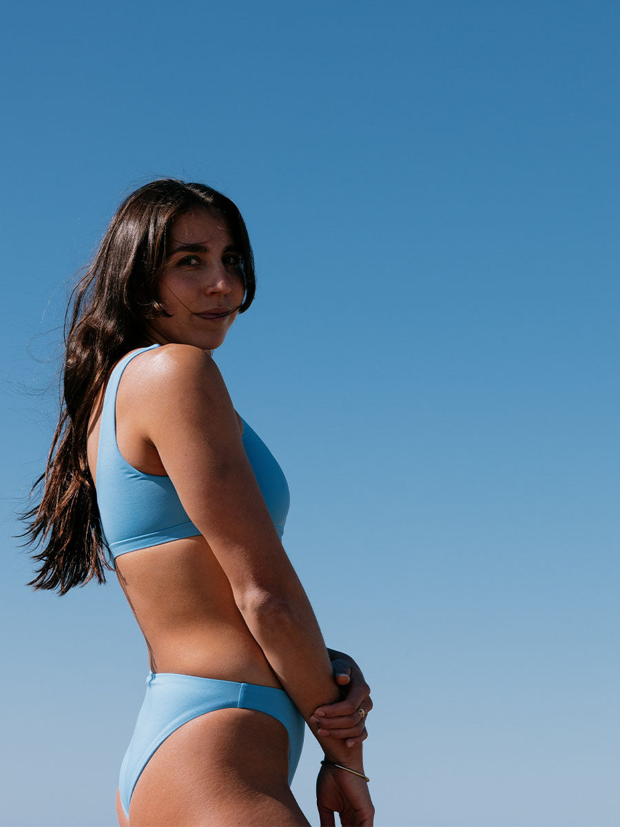 Woman in JAYD Nalu blue bikini against a clear blue sky. Blue colour is called Breeze