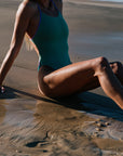 athletic swimmer wearing the IBIZA swimsuit made by JAYD Swimwear in the Matcha colours, suit features include contrasting straps and hip cut outs. Built for performance.