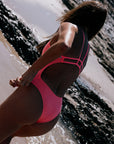 Person wearing a vibe coloured one piece one a beach. She is wearing the JAYD swimwear Zimmy one piece.