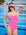 JAYD Swimwear model Adri standing in front of a pool wearing the Albi one piece in Pink Sorbet with Contrasting Mykonos blue straps.