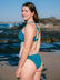 JAYD model Milly wearing the Amalfi bikini bottoms in Cove on a rocky beach with ocean waves and a clear blue sky in the background.