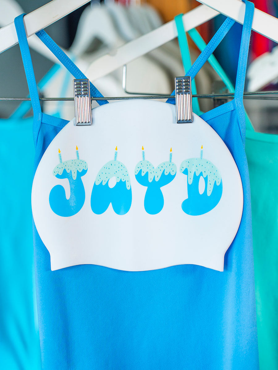 Swim Cap hanging on a rack with blue swimsuit