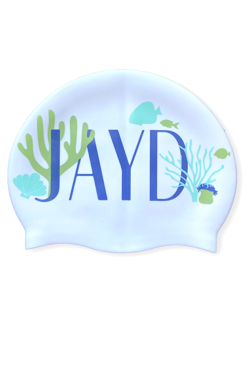White swim cap with 'JAYD' logo and underwater-themed blue and green corals, fish and shells.