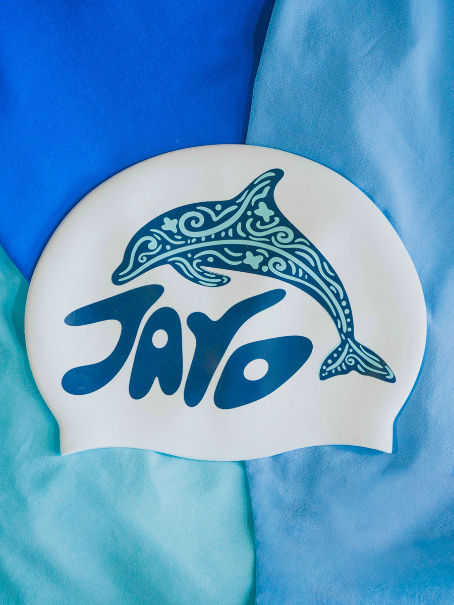 White swim cap with blue dolphin design and 'JAYD' text on a blue background