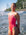 JAYD Swimwear athlete Claudia Slaven standing on a beach wearing the Finley one piece swimsuit in fiesta with contrasting fairy floss pink shoulder straps.