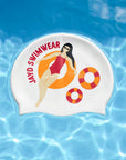 A white swim cap featuring a cartoon illustration of a woman in a red swimsuit lounging on an orange float, with the text 'JAYD SWIMWEAR' in red. The swim cap is shown floating on a bright blue water background with ripples.