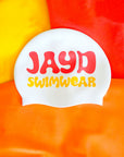 White swim cap with 'JAYD Swimwear' text on a colorful background