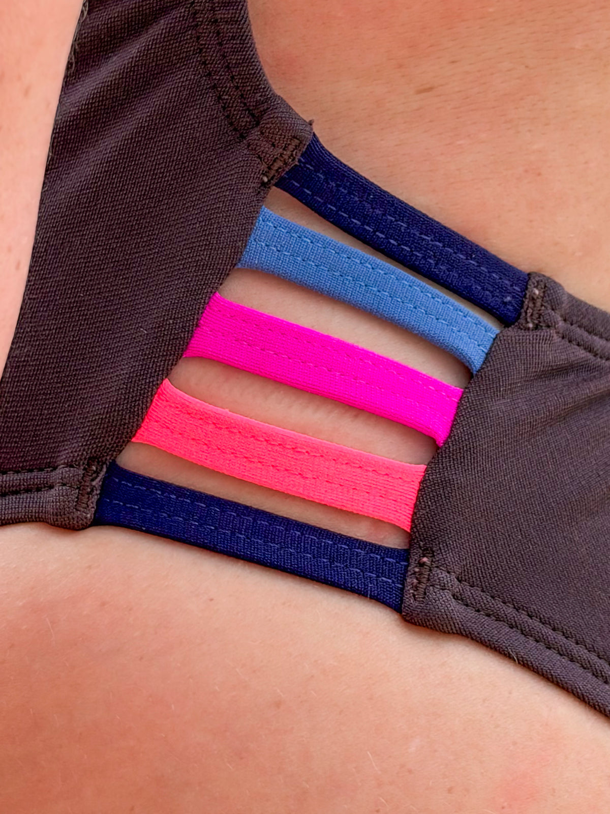 Close up of the Lennox one piece in cacao with contrasting multi-coloured straps.